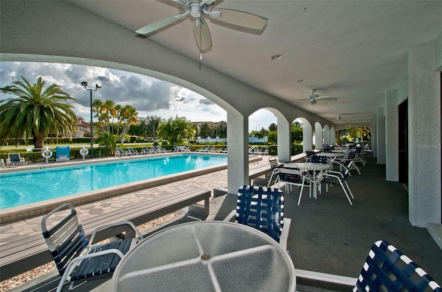 view of swimming pool with ceiling fan and a patio