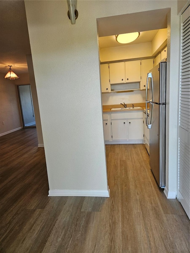 kitchen featuring sink, hardwood / wood-style flooring, and stainless steel fridge