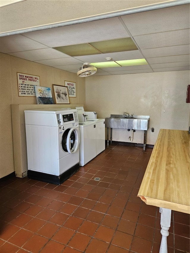 laundry room featuring washing machine and clothes dryer and dark tile patterned flooring