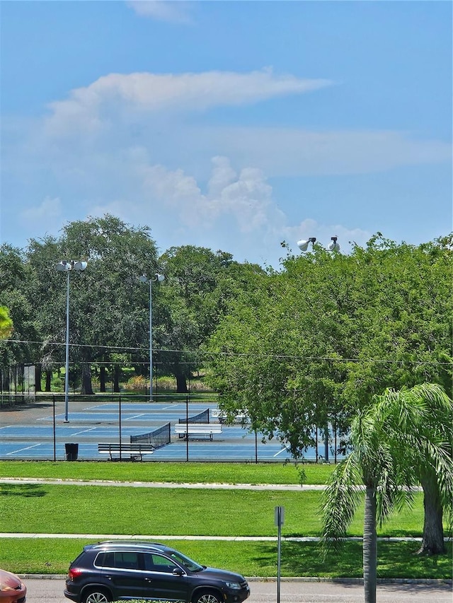 view of sport court featuring a lawn