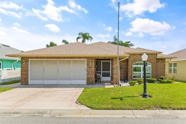 single story home featuring a garage and a front yard