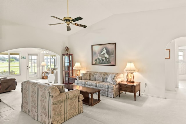 living room with ceiling fan, high vaulted ceiling, and light colored carpet