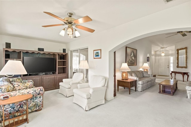 carpeted living room with ceiling fan