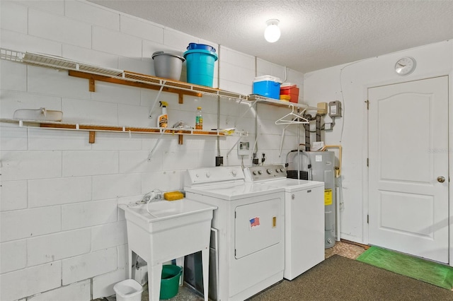 laundry area with washing machine and dryer, a textured ceiling, and electric water heater