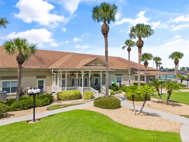 view of front facade with a front lawn, cooling unit, and covered porch