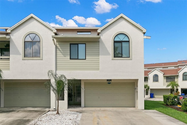 view of front facade featuring a garage, driveway, and stucco siding