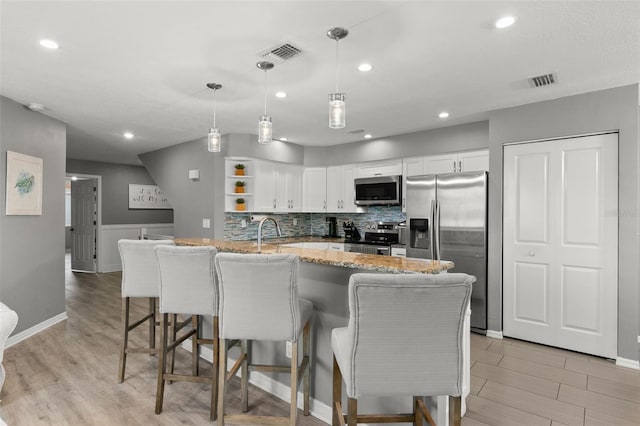 kitchen with decorative light fixtures, open shelves, stainless steel appliances, visible vents, and white cabinets