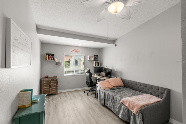 bedroom with a textured ceiling, light wood finished floors, a ceiling fan, and baseboards