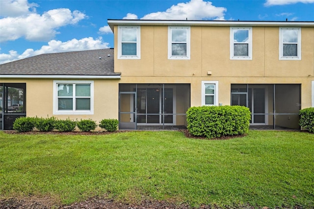 rear view of property with a lawn and stucco siding