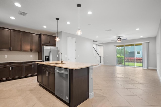 kitchen with a sink, visible vents, open floor plan, appliances with stainless steel finishes, and pendant lighting