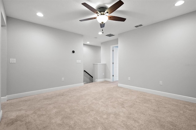 empty room with baseboards, visible vents, and light colored carpet