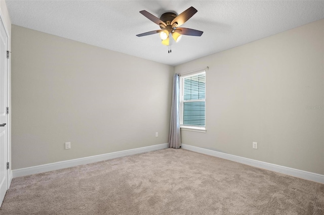 empty room with light carpet, ceiling fan, a textured ceiling, and baseboards