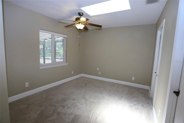 unfurnished bedroom featuring a skylight and ceiling fan