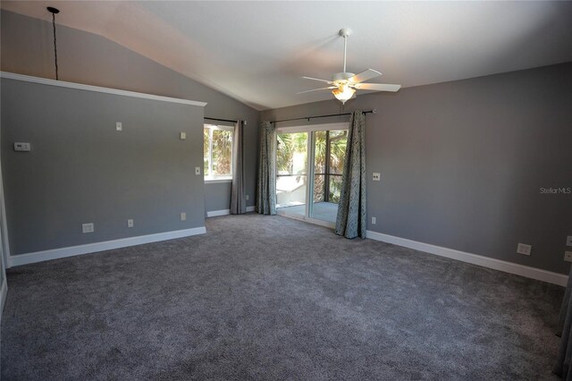 empty room featuring ceiling fan, vaulted ceiling, and carpet