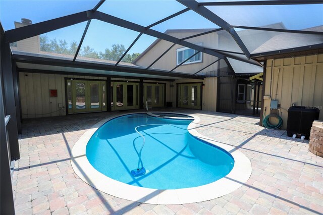 view of swimming pool with glass enclosure and a patio area