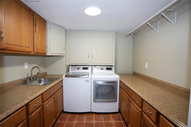 laundry room featuring cabinets, dark tile patterned flooring, sink, and independent washer and dryer