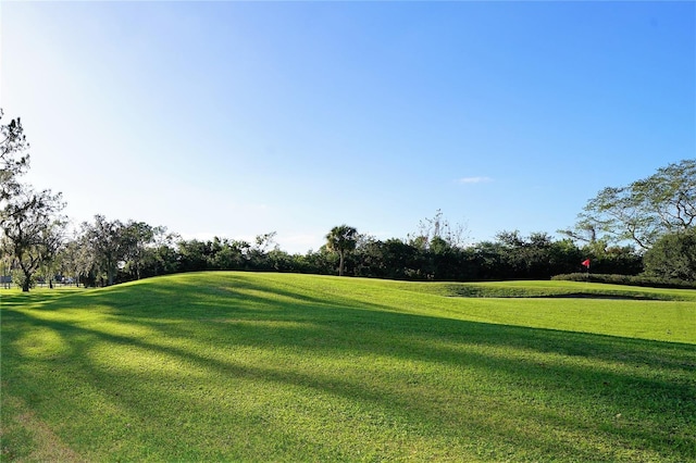 view of home's community featuring a lawn and view of golf course