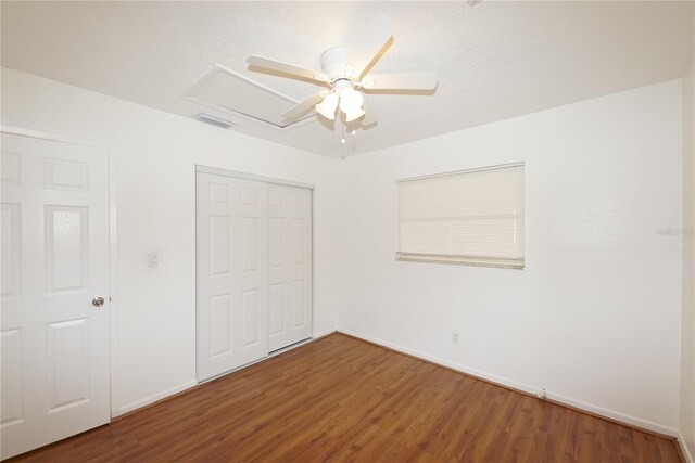 unfurnished bedroom with ceiling fan, a closet, and wood-type flooring