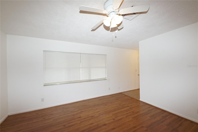 empty room with ceiling fan, wood-type flooring, and a textured ceiling