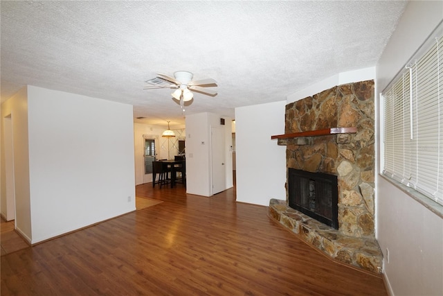 unfurnished living room featuring hardwood / wood-style floors, ceiling fan, a textured ceiling, and a fireplace