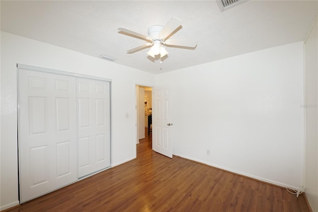 unfurnished bedroom with hardwood / wood-style flooring, a closet, and ceiling fan