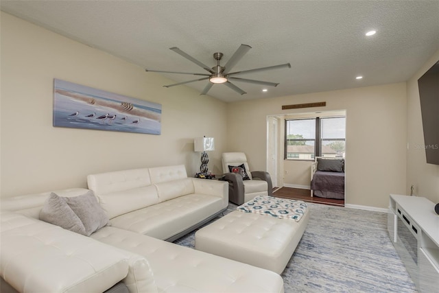 living room featuring a textured ceiling, wood-type flooring, and ceiling fan