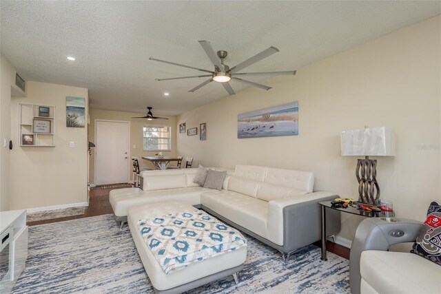 living room featuring a textured ceiling and ceiling fan