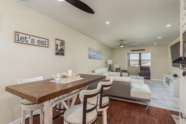 dining area with ceiling fan, dark hardwood / wood-style flooring, and a textured ceiling