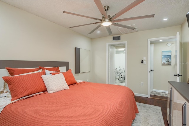 bedroom featuring connected bathroom, ceiling fan, a textured ceiling, and hardwood / wood-style floors