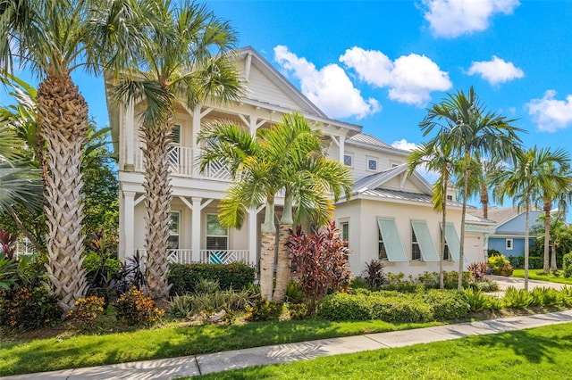 view of front of house featuring a front lawn and a balcony