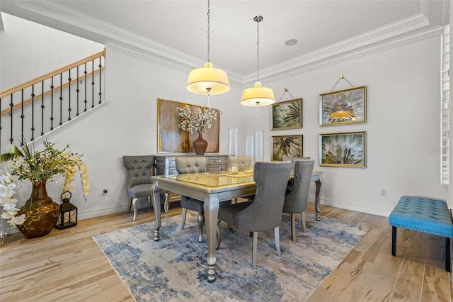 dining area featuring light hardwood / wood-style flooring, crown molding, and a chandelier