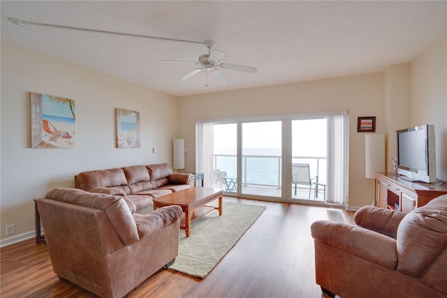 living room with ceiling fan, hardwood / wood-style floors, and a textured ceiling