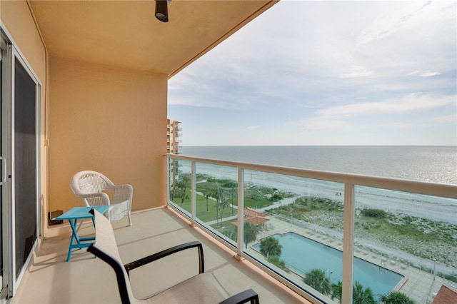 balcony featuring a water view and a view of the beach