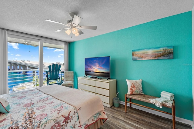 bedroom with hardwood / wood-style flooring, ceiling fan, and a textured ceiling