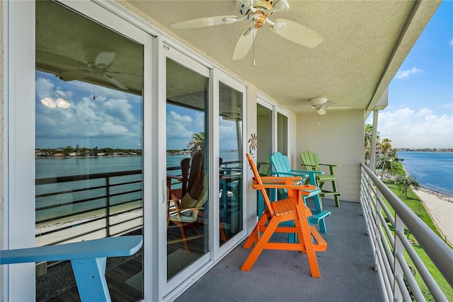 balcony featuring a water view and ceiling fan