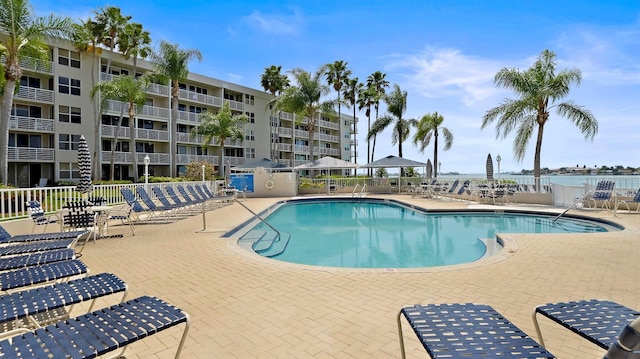 view of pool featuring a patio and a water view