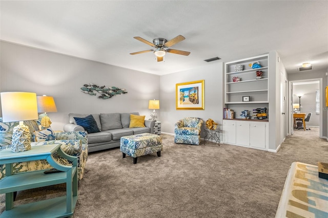 carpeted living area with baseboards, visible vents, and a ceiling fan