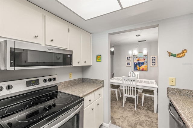 kitchen featuring white cabinets, an inviting chandelier, and stainless steel appliances