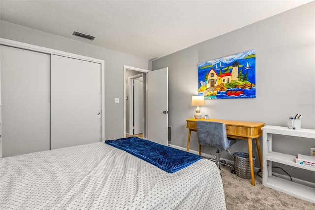 bedroom featuring light carpet, a closet, and a textured ceiling