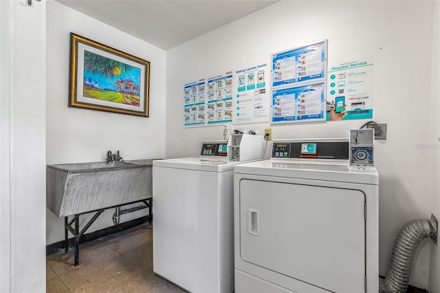 clothes washing area with sink, dark tile patterned flooring, and separate washer and dryer