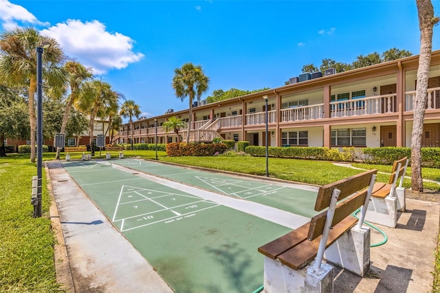 surrounding community with shuffleboard and a yard