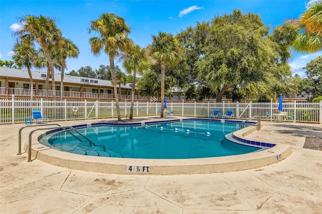 pool with a patio area and fence