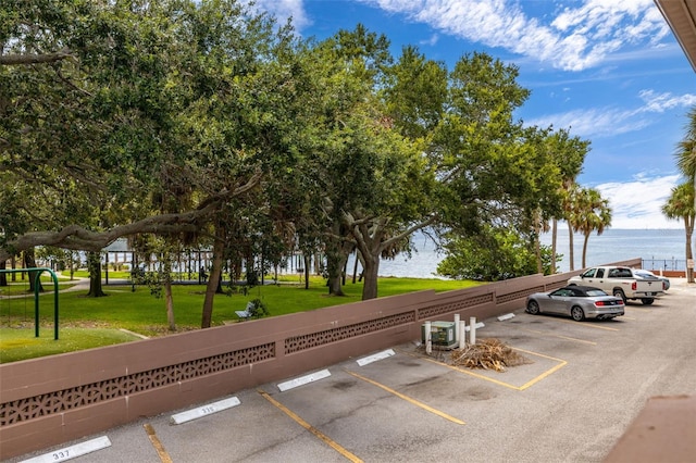 uncovered parking lot featuring a water view