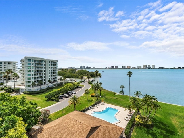 view of swimming pool featuring a patio and a water view