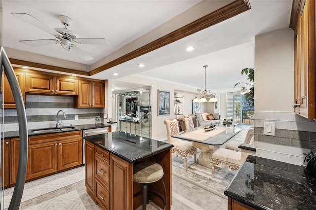 kitchen with tasteful backsplash, pendant lighting, a center island, and sink