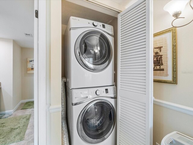 100 Oakmont Ln Unit 301, Belleair, FL 33756 - laundry room featuring stacked washer / drying machine and baseboards