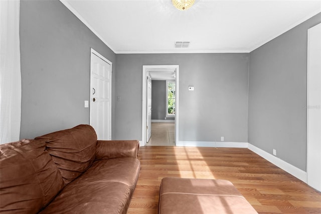 unfurnished living room with light wood-type flooring and ornamental molding