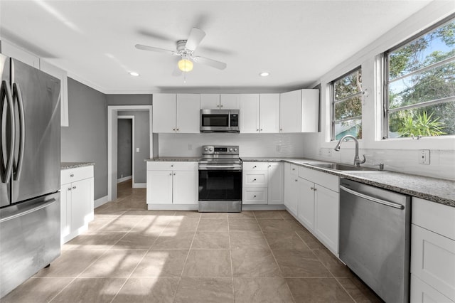 kitchen featuring light tile patterned floors, appliances with stainless steel finishes, sink, and white cabinetry