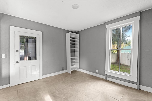 tiled empty room featuring a wealth of natural light