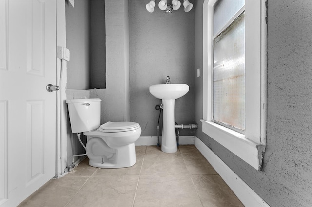 bathroom featuring sink, toilet, and tile patterned flooring